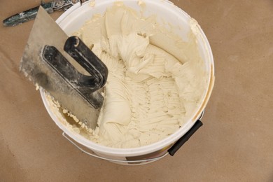 Photo of Bucket with cement and putty knifes, above view