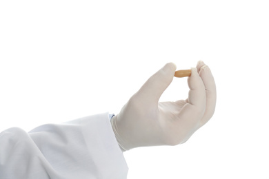 Doctor holding suppository for hemorrhoid treatment on white background, closeup