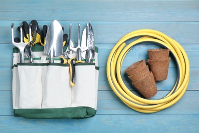 Flat lay composition with gardening tools on light blue wooden background