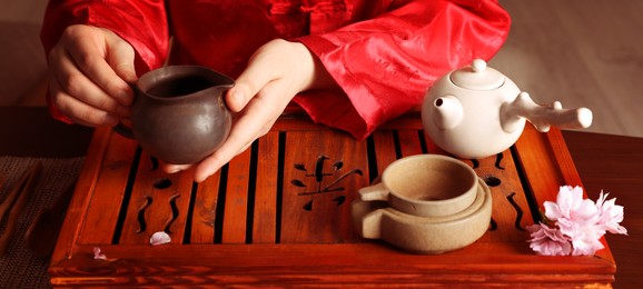 Master conducting traditional tea ceremony at table indoors, closeup. Banner design