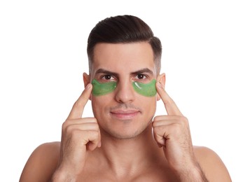 Man applying green under eye patches on white background