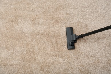 Photo of Removing dirt from carpet with modern vacuum cleaner indoors, top view. Space for text