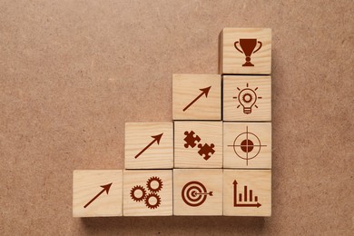 Wooden cubes with different images on brown background, flat lay