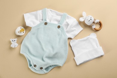 Flat lay composition with baby clothes and accessories beige background