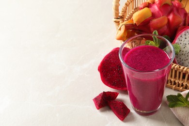 Delicious pitahaya smoothie and fresh fruits on light grey table, space for text