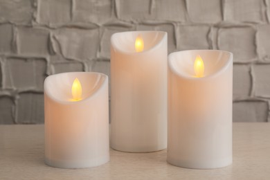 Decorative LED candles on white wooden table