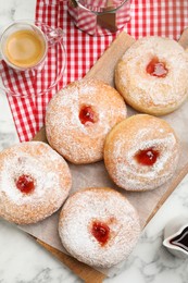 Delicious jam donuts served with coffee on white marble table, flat lay