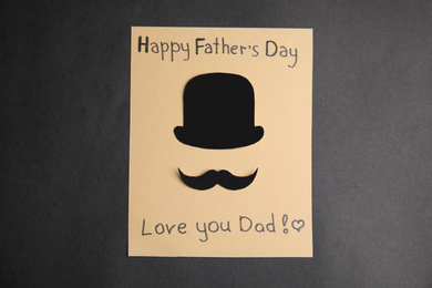 Greeting card with phrase HAPPY FATHER'S DAY I LOVE YOU DAD on black background, top view