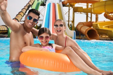 Happy family taking selfie in swimming pool at water park
