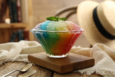 Rainbow shaving ice in glass dessert bowl on wooden  table indoors