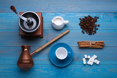 Photo of Flat lay composition with vintage manual coffee grinder and turkish pot on light blue wooden background