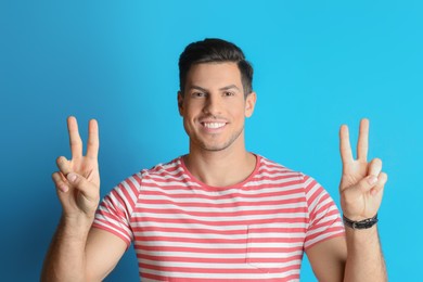 Man showing number four with his hands on light blue background