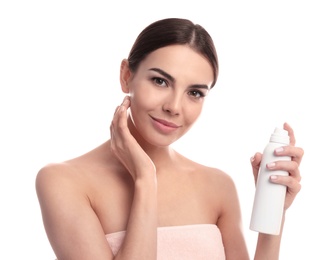 Young woman with bottle of thermal water on white background. Cosmetic product