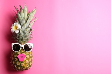 Photo of Top view of funny pineapple with sunglasses, lips and plumeria flower on pink background, space for text. Creative concept