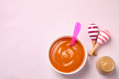 Healthy baby food and maracas on light background, flat lay. Space for text