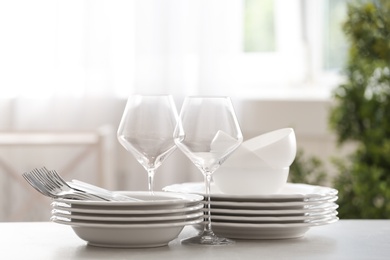 Set of clean dishware, cutlery and wineglasses on table indoors