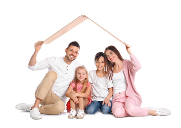Happy family sitting under cardboard roof on white background. Insurance concept