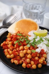 Delicious chickpea curry with rice on table, closeup