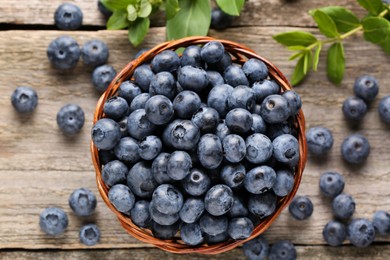 Tasty fresh blueberries on wooden table, flat lay