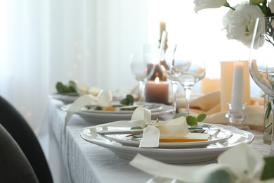 Photo of Festive table setting with beautiful floral decor in restaurant, space for text