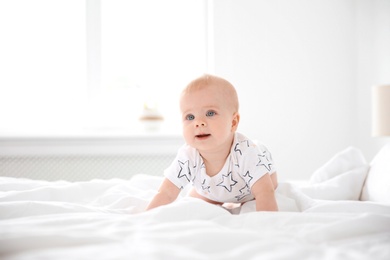 Cute little baby crawling on bed at home