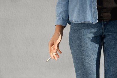 Woman with cigarette outdoors, closeup. Space for text