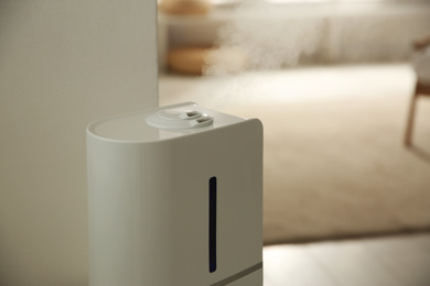 Modern humidifier in room. Space for text