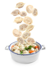 Many tasty dumplings falling into bowl on white background