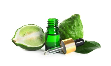 Bottle of essential oil, fresh bergamot fruits and leaves on white background