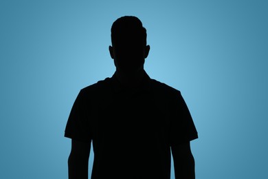 Silhouette of anonymous man on light blue background