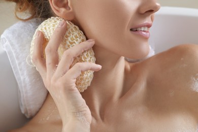 Woman rubbing her neck with sponge while taking bath, closeup