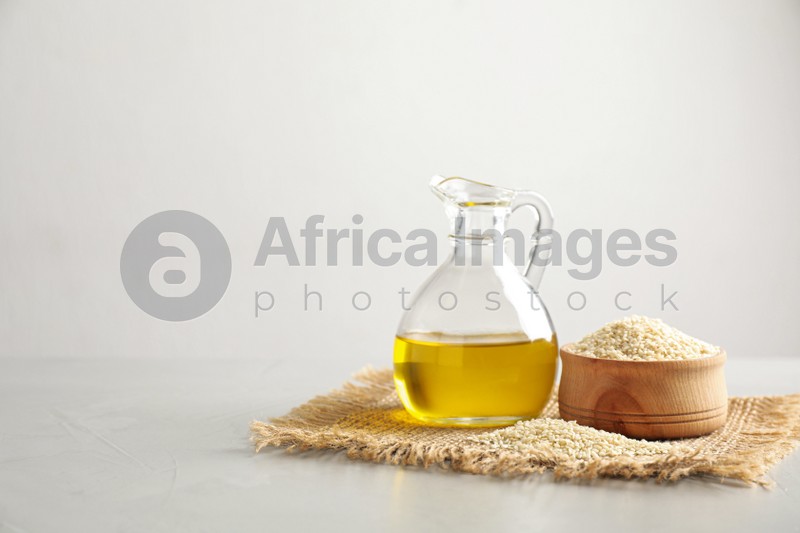 Fresh sesame oil and seeds on white table. Space for text