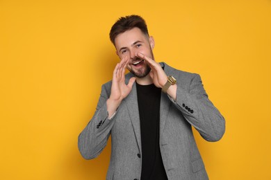 Photo of Handsome man in stylish grey jacket screaming on yellow background