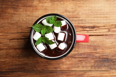 Photo of Mug of delicious hot chocolate with marshmallows and fresh mint on wooden table, top view