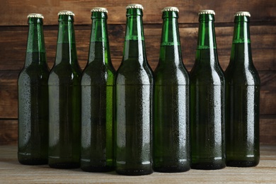 Photo of Green bottles of beer on wooden table