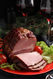Photo of Plate with delicious ham, lettuce and tomatoes on black wooden table