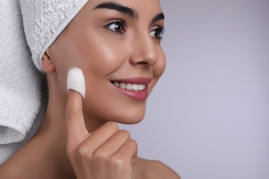 Photo of Woman using silkworm cocoon in skin care routine on light grey background, closeup. Space for text