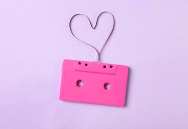 Music cassette and heart made with tape on violet background, top view. Listening love song
