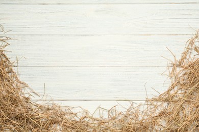 Photo of Dried hay on white wooden background, flat lay. Space for text