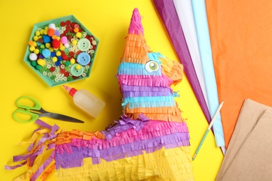 Flat lay composition with cardboard donkey and materials on yellow background. Pinata DIY