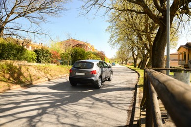 Photo of Picturesque view of beautiful suburban street with cars on sunny spring day