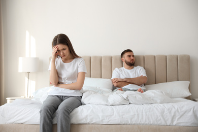 Unhappy couple with problems in relationship on bed at home