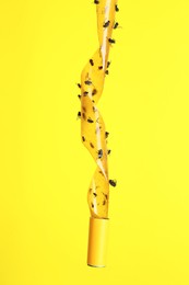 Sticky insect tape with dead flies on yellow background