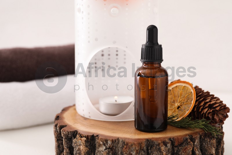Aroma lamp and coniferous essential oil on stump