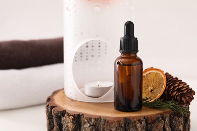Aroma lamp and coniferous essential oil on stump