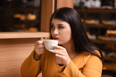 Beautiful overweight woman in cafe. Plus size model