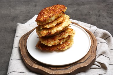 Photo of Stack of tasty parsnip cutlets on grey textured table