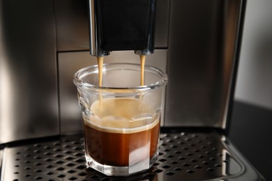 Espresso machine pouring coffee into glass, closeup