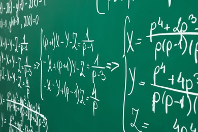 Many different math formulas written on chalkboard, closeup