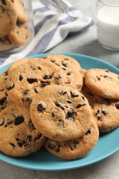 Plate with delicious chocolate chip cookies on grey marble table, closeup